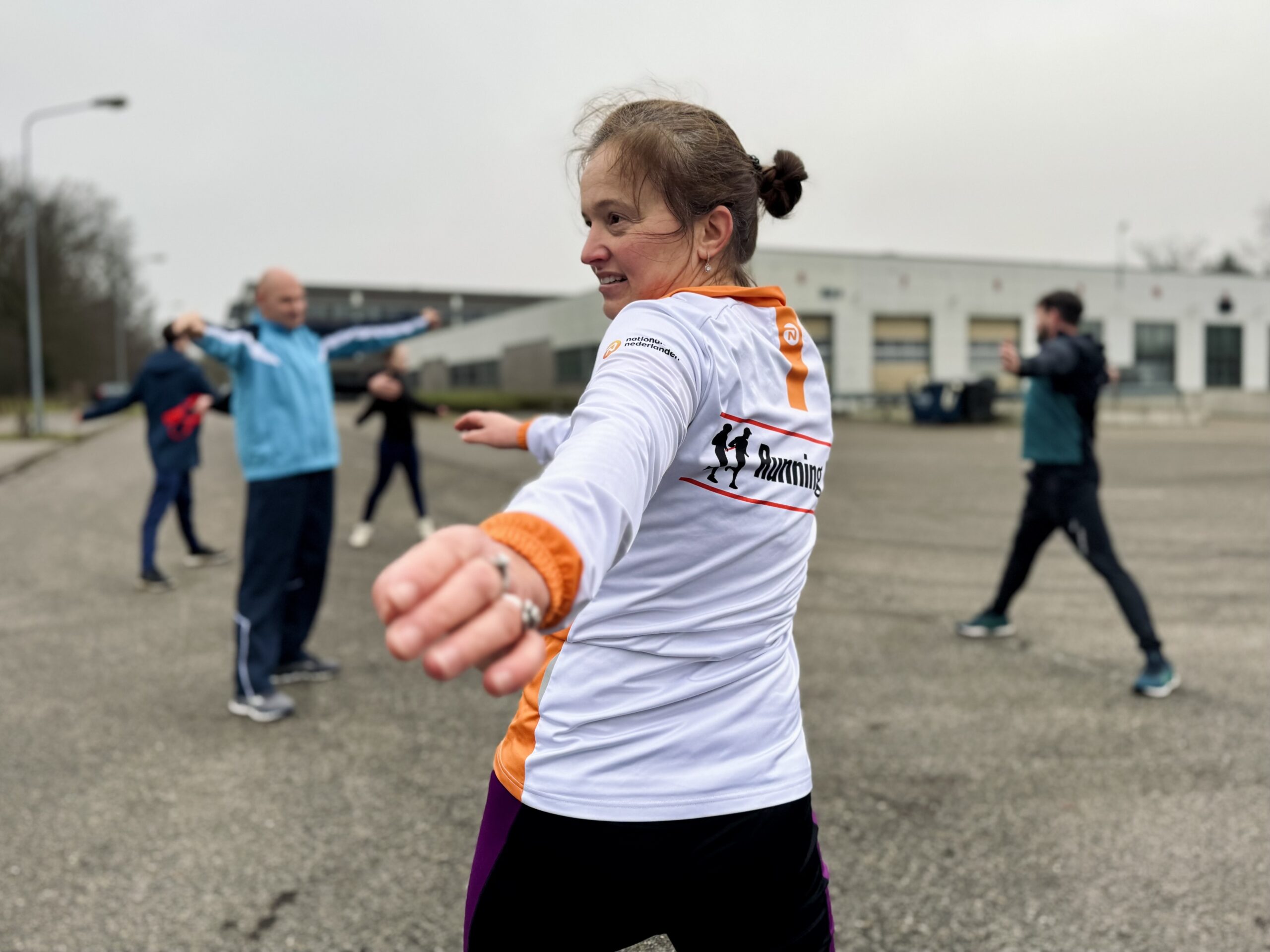 Running Blind coach die een warming-up aan het geven is.