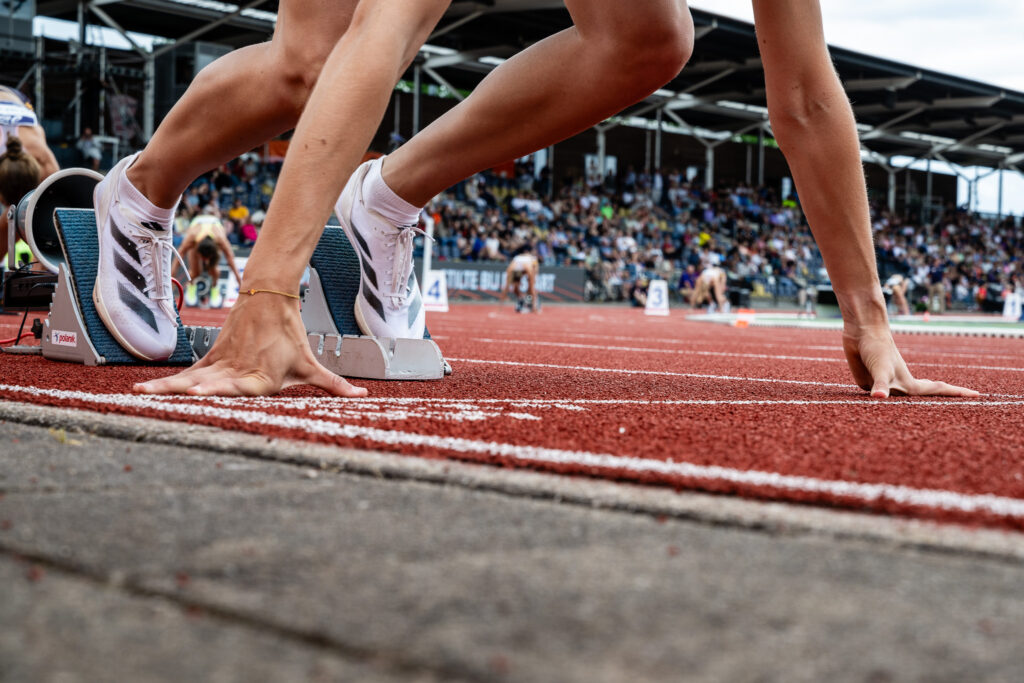 close up van een atleet in de startblokken op een atletiekbaan