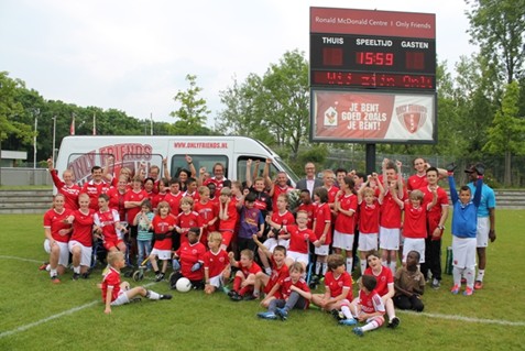 groepsfoto van sporters en vrijwilligers van sportvereniging only friends voor de gedoneerde connexxion bus