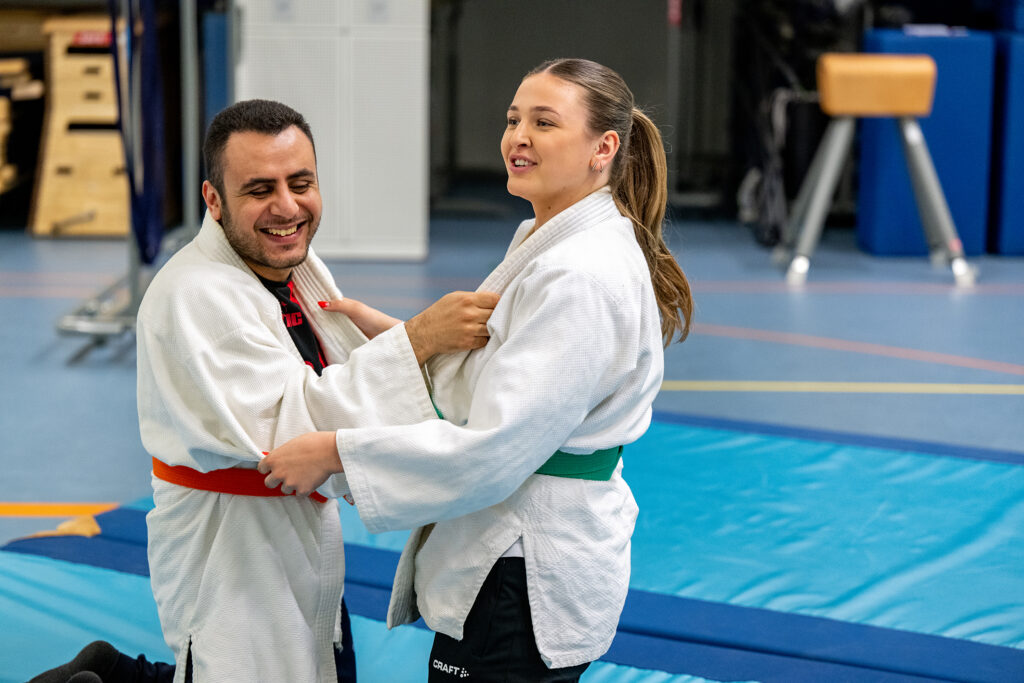 twee personen die judo doen. de ene legt het uit aan de ander