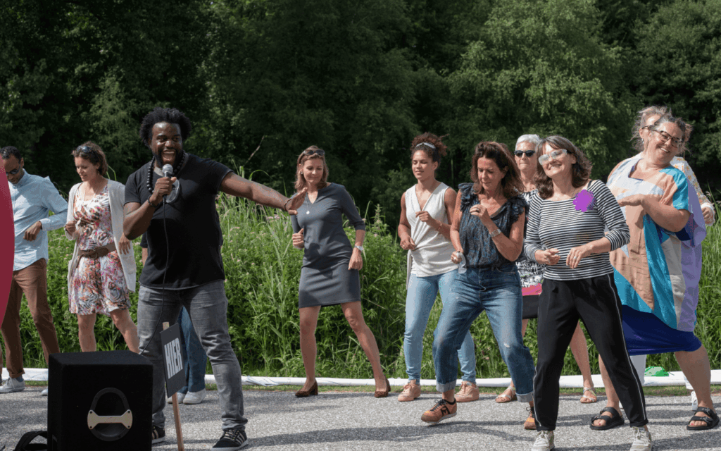 enthousiaste dansers dansen buiten met een man met microfoon