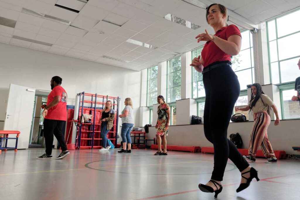 dansinstructeur met deelnemers op de achtergrond