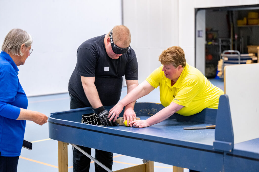 deelnemer krijgt uitleg van een instructeur over showdown bij een showdowntafel