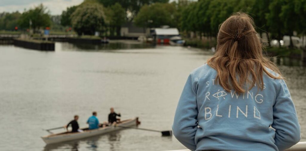 closeup van rowing blind vrijwilliger met roeiers op de achtergrond