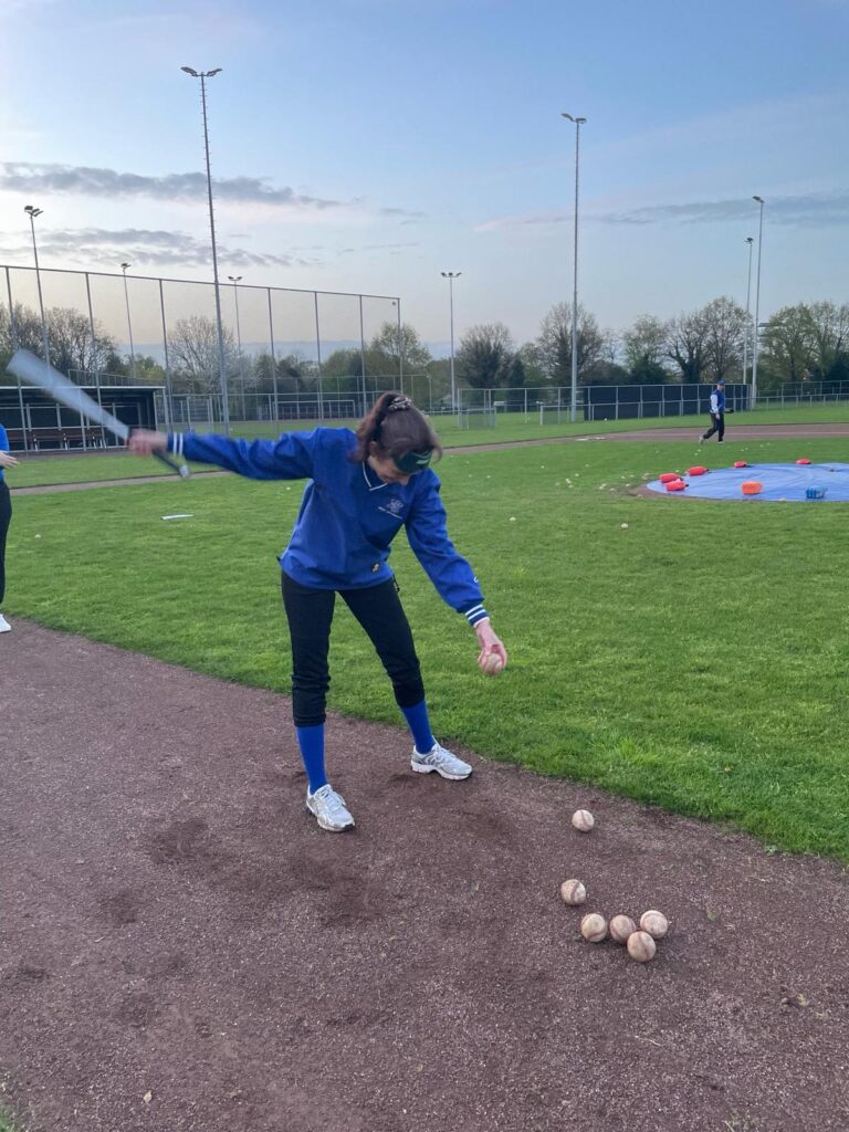 marloes staat klaar met een knuppel om de bal te slaan