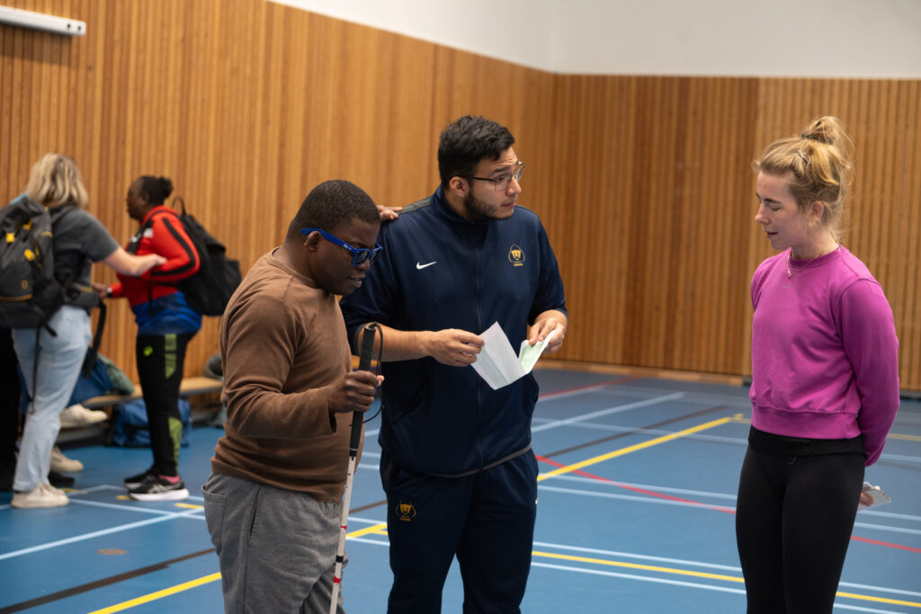 buddy helpt deelnemer en is in gesprek met een sportaanbieder