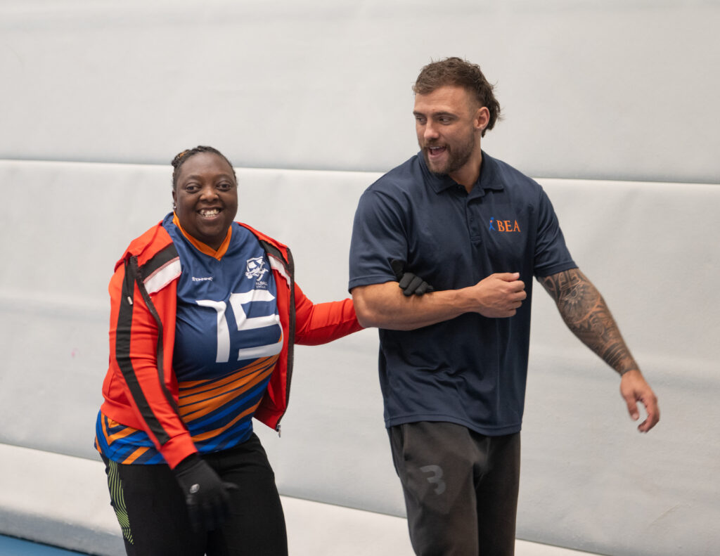 trainer begeleidt sporter in een sportzaal