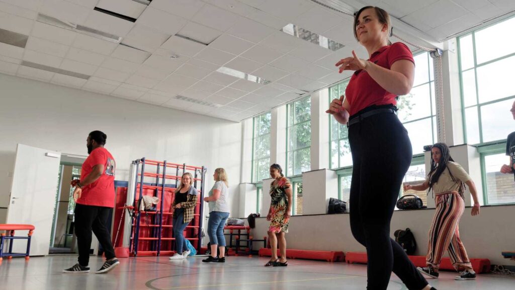 Salsa dansende vrouw op de vroorgrond in een zaal.