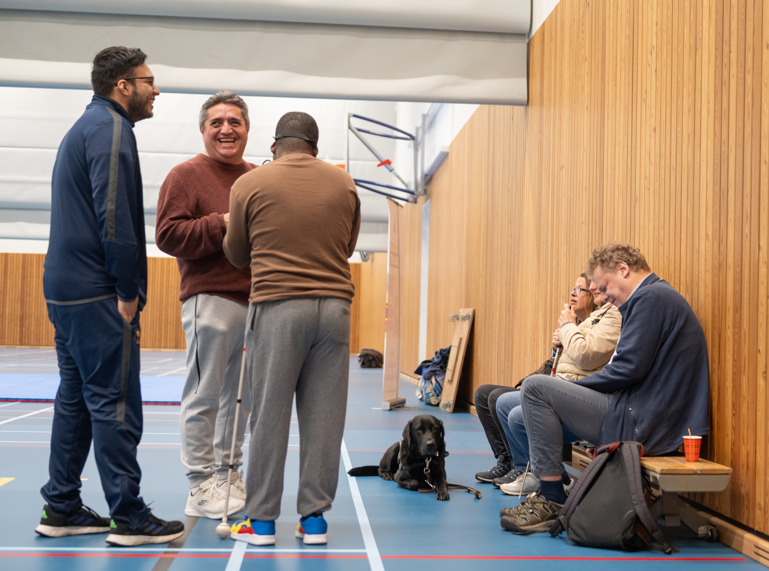 deelnemers in gesprek met elkaar bij binnenkomst in de sportzaal