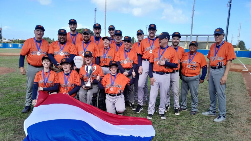Het hele blind baseball team op de foto met een Nederlandse vlag en een beker.